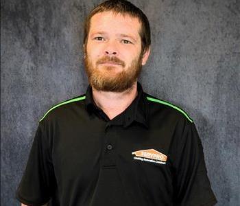 Male employee standing in front of grey backdrop