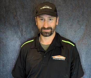 Male employee standing in front of grey backdrop