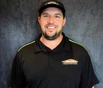 Male employee standing in front of grey backdrop