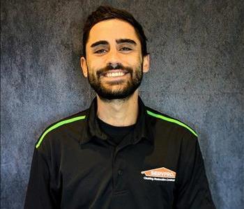 Male employee standing in front of grey backdrop