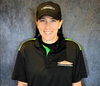 Female employee standing in front of grey backdrop