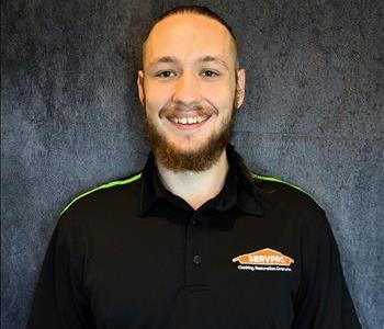 Male employee standing in front of grey backdrop