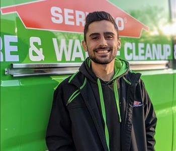 Male standing in front of green SERVPRO truck