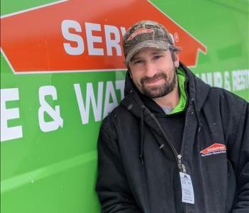 Male standing in front of green SERVPRO truck