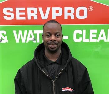 Male standing in front of green SERVPRO truck